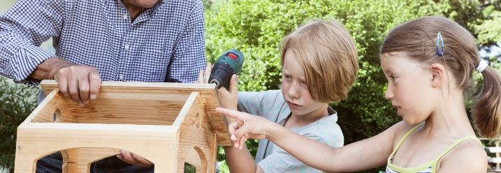 Kinder helfen Großvater beim Bau vom Vogelhaus